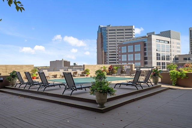 wooden deck with a patio area and a community pool