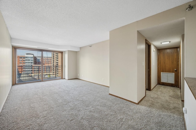 unfurnished room featuring light carpet and a textured ceiling