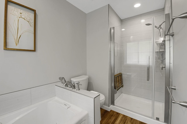 bathroom featuring hardwood / wood-style flooring, toilet, and separate shower and tub