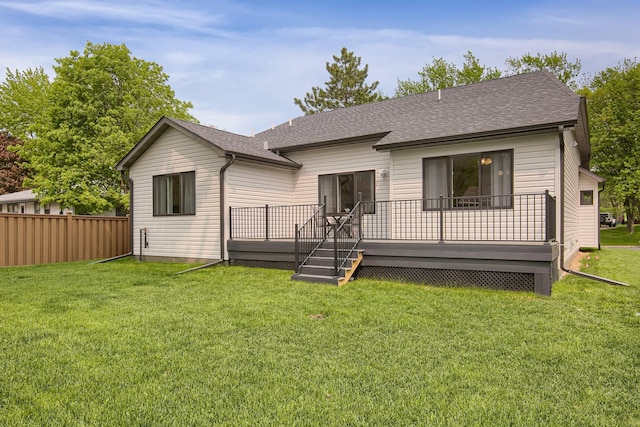 rear view of house featuring a lawn and a deck