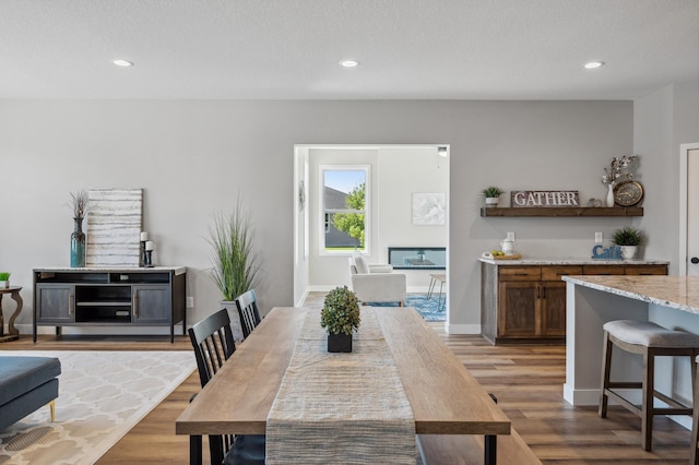 dining space with light hardwood / wood-style flooring and a textured ceiling