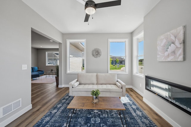 living room featuring plenty of natural light, dark hardwood / wood-style floors, and ceiling fan