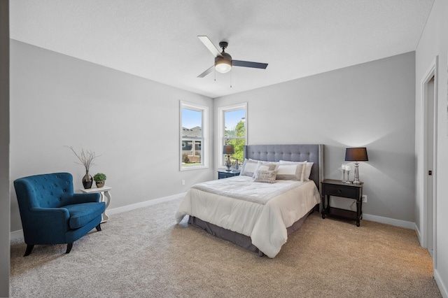 bedroom featuring light carpet, a textured ceiling, and ceiling fan