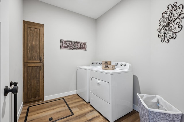 laundry area with washer and dryer and light wood-type flooring