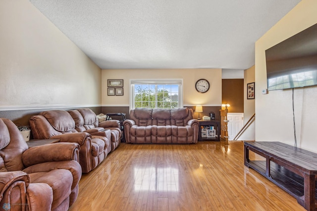 living room with a textured ceiling and light hardwood / wood-style flooring