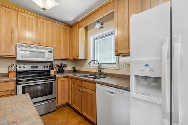 kitchen featuring white appliances, light hardwood / wood-style floors, and sink