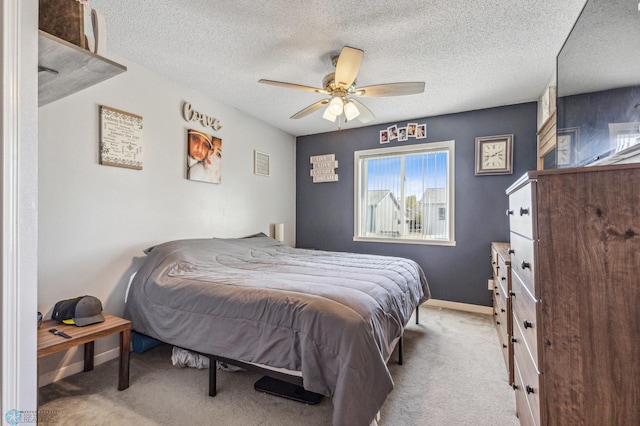 carpeted bedroom with ceiling fan and a textured ceiling