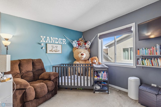 carpeted bedroom with a textured ceiling and a crib