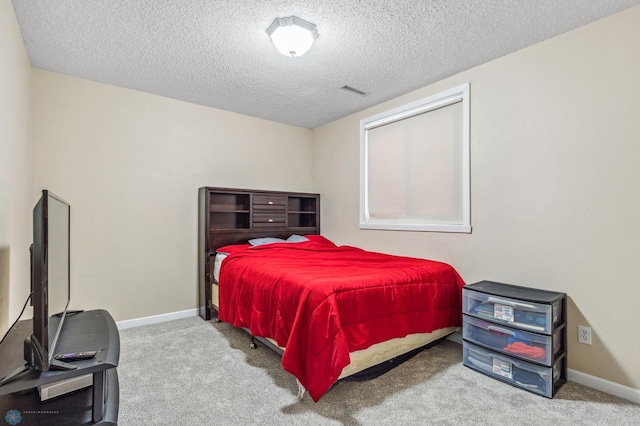 bedroom featuring a textured ceiling and light colored carpet