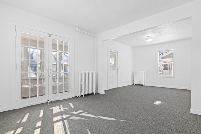 empty room with radiator, a healthy amount of sunlight, and dark carpet