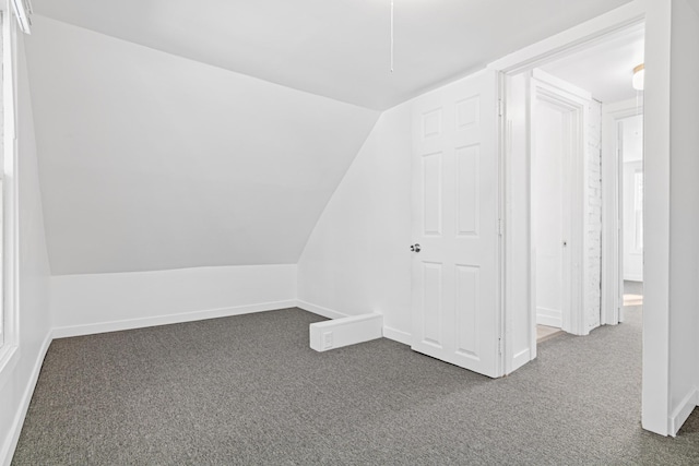 bonus room featuring dark carpet and vaulted ceiling