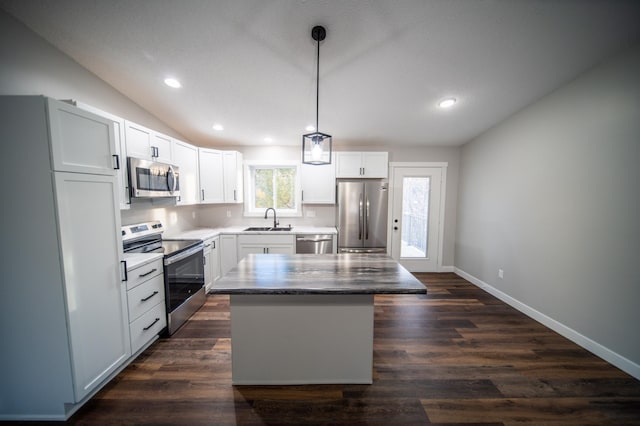 kitchen with pendant lighting, a center island, sink, white cabinetry, and appliances with stainless steel finishes