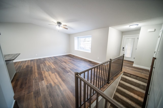 interior space featuring dark wood-type flooring, lofted ceiling, and ceiling fan