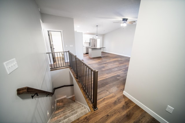 stairway with ceiling fan and hardwood / wood-style floors