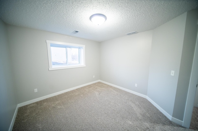 carpeted empty room with a textured ceiling