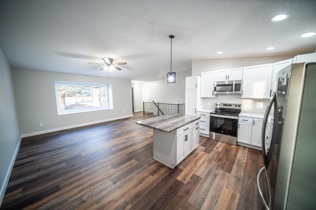 kitchen featuring pendant lighting, white cabinets, appliances with stainless steel finishes, a kitchen island, and ceiling fan