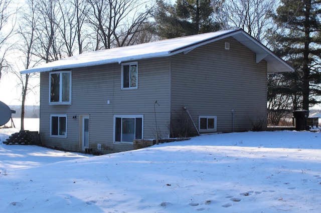 view of snow covered back of property