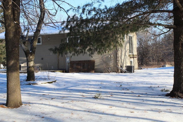 snow covered rear of property featuring cooling unit