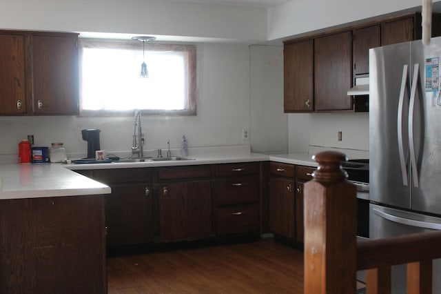 kitchen with decorative light fixtures, dark brown cabinetry, stainless steel fridge, and dark hardwood / wood-style floors