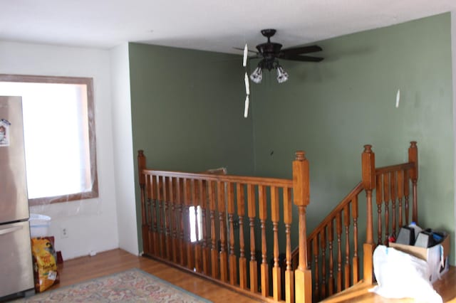 stairway with ceiling fan and hardwood / wood-style flooring