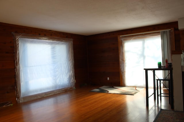 spare room featuring wood-type flooring and wood walls