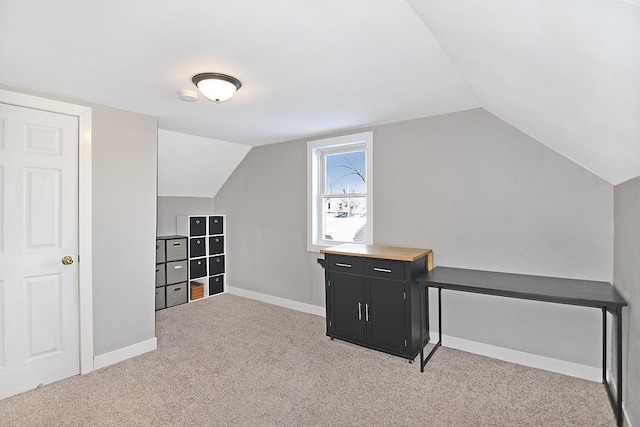 bonus room with lofted ceiling and light carpet