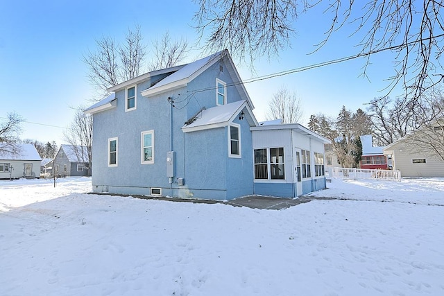 snow covered house with a sunroom