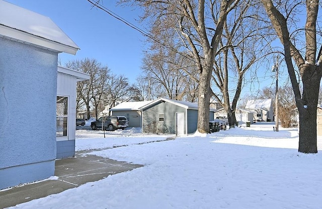 yard covered in snow featuring an outbuilding