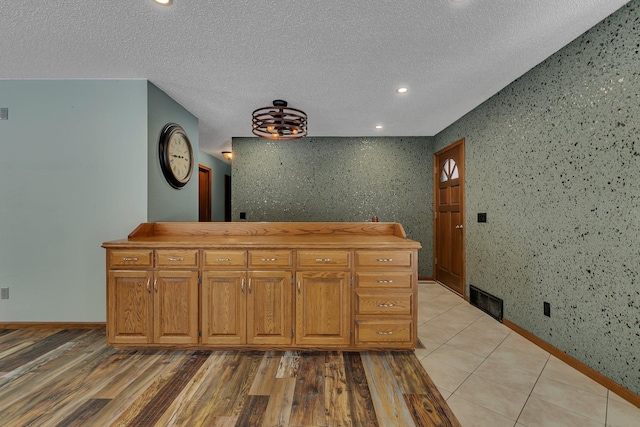 interior space with a textured ceiling, butcher block counters, and light wood-type flooring