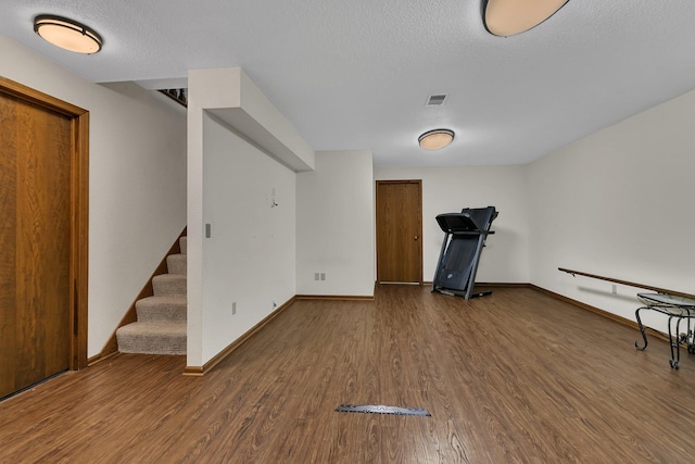 exercise area featuring hardwood / wood-style flooring and a textured ceiling