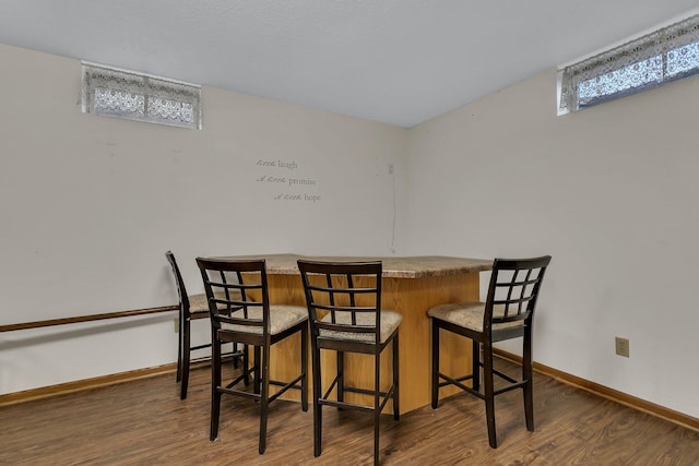 dining room featuring bar area and dark hardwood / wood-style flooring