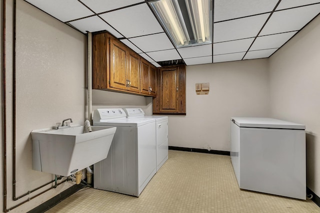 washroom featuring cabinets, washer and clothes dryer, and sink