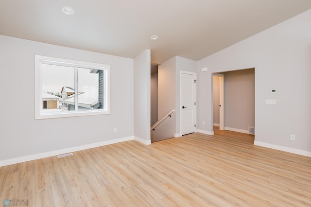 unfurnished room with lofted ceiling and light hardwood / wood-style floors