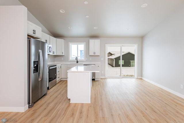 kitchen featuring a kitchen island, stainless steel appliances, white cabinets, and sink