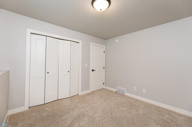 unfurnished bedroom with a closet and carpet floors