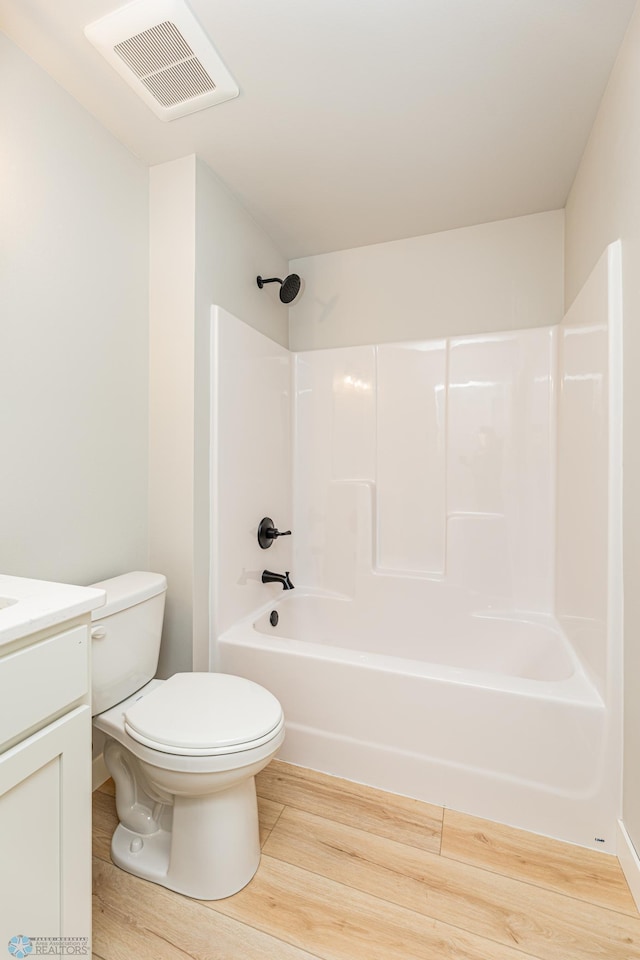 full bathroom featuring shower / bathing tub combination, hardwood / wood-style floors, vanity, and toilet