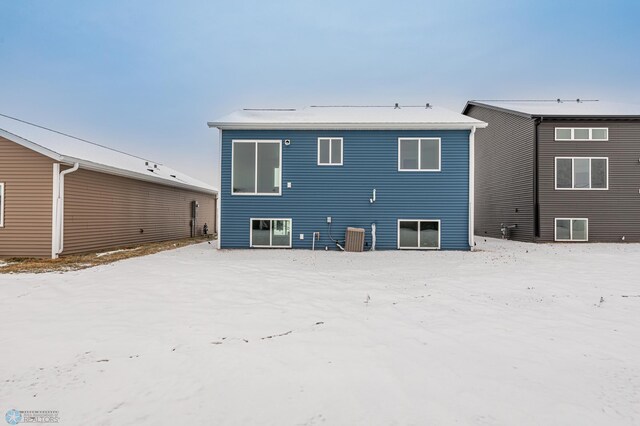 view of snow covered back of property