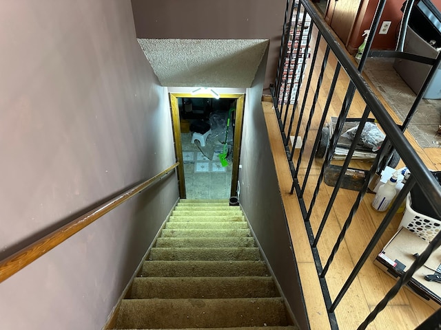 staircase with a textured ceiling