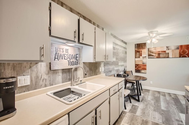 kitchen featuring ceiling fan, white cabinetry, tasteful backsplash, and sink