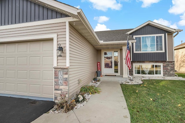 entrance to property with a garage and a yard