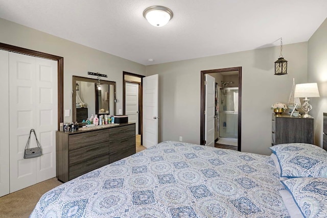 carpeted bedroom with a closet and ensuite bath