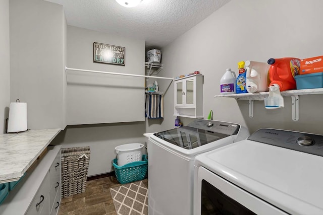 clothes washing area featuring cabinets, a textured ceiling, and independent washer and dryer