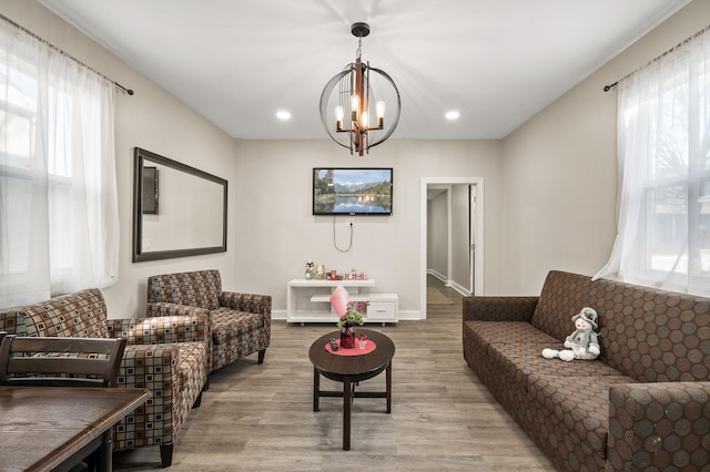 living room with a notable chandelier and light hardwood / wood-style floors