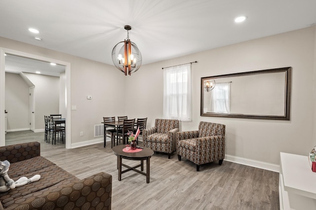 living room featuring a chandelier and light hardwood / wood-style flooring