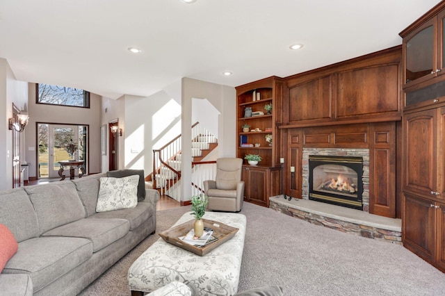 living room with stairway, built in shelves, carpet, recessed lighting, and a stone fireplace