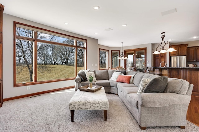 living room featuring visible vents, baseboards, light carpet, recessed lighting, and a notable chandelier