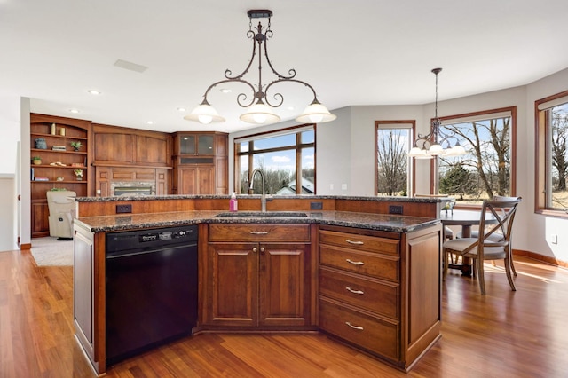 kitchen featuring black dishwasher, wood finished floors, a chandelier, and a sink