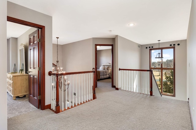 corridor with recessed lighting, an upstairs landing, carpet floors, and an inviting chandelier