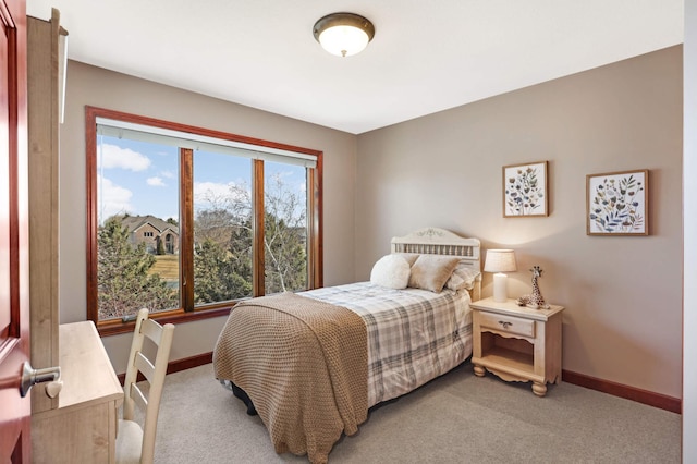 bedroom with light carpet and baseboards