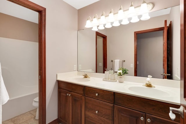 bathroom with tile patterned floors, toilet, double vanity, and a sink